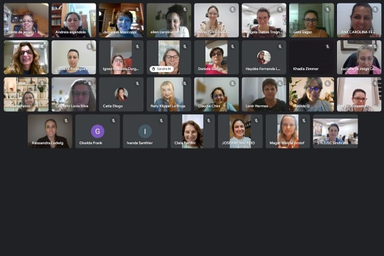 A imagem apresenta uma conferência online, onde 31 mulheres estão presentes, 26 delas estão com as câmeras ligadas e seus rostos aparecem na tela. As que estão com a câmera desligada, tem a inicial do seu nome na tela e um círculo colorido em volta.